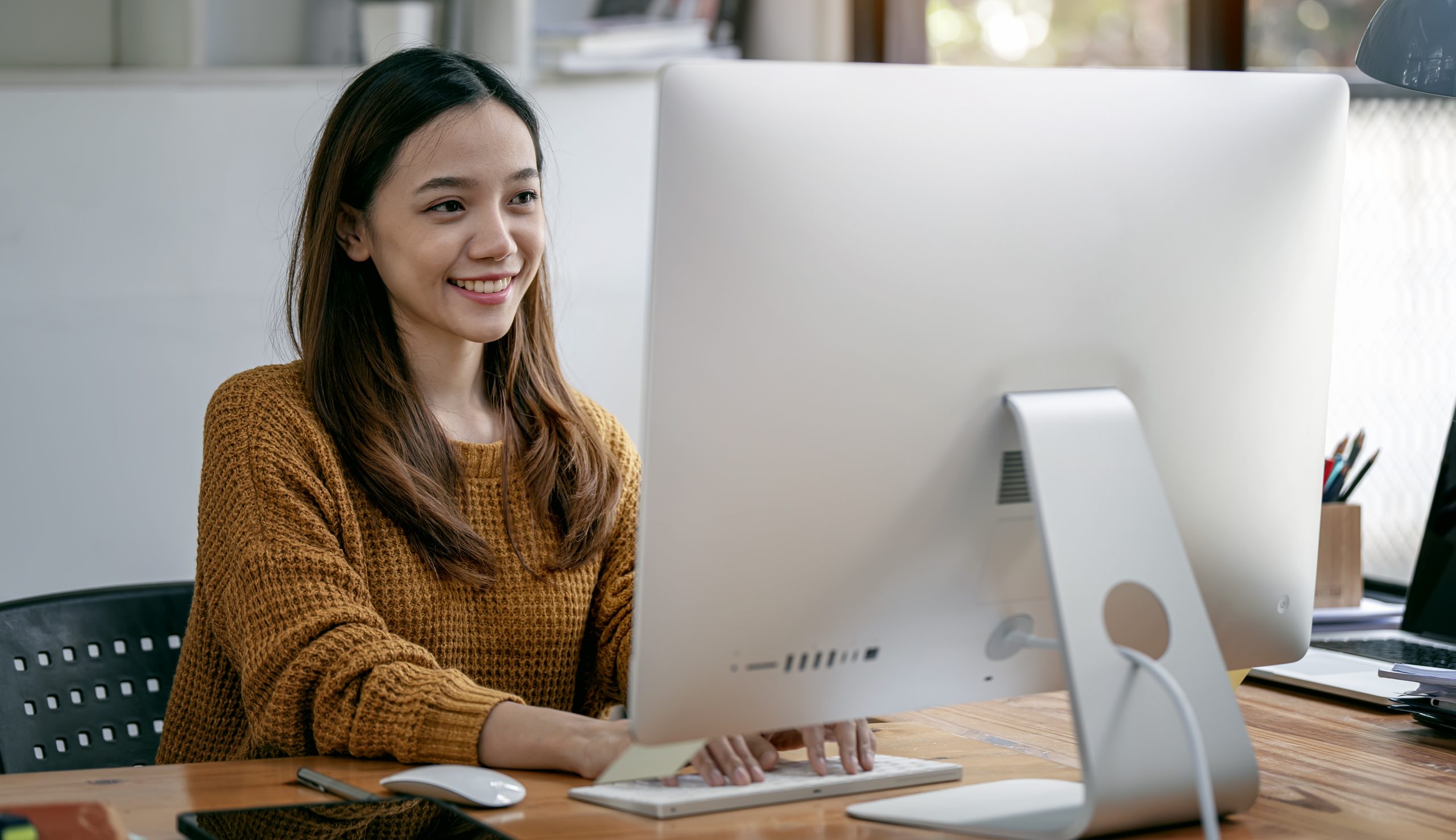 Focused young coworkers checking information on laptop